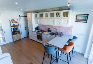 a kitchen with white cabinets and a table and chairs at Hidden Gem Townhouse - Cahersiveen in Cahersiveen