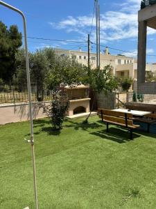 ein Park mit einer Bank und einem Tisch im Hof in der Unterkunft Harmony 1 in Áyios Spirídhon