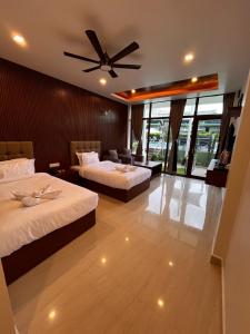 a hotel room with two beds and a ceiling fan at Emmonlang Resort and Restaurant in Dingpasoh