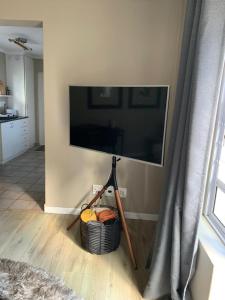 a living room with a television and a basket of fruit at The Cottage on Alphen in Heathfield