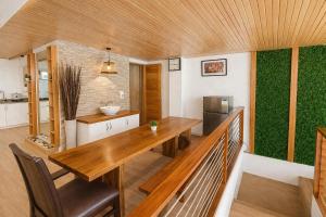 a kitchen with a wooden table and a green wall at Taj Resort and Spa in Boracay