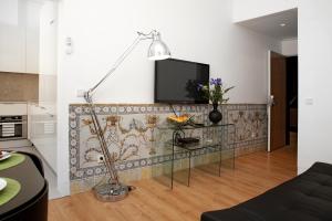 a living room with a table and a tv on a wall at LSA Baixa Chiado by Numa in Lisbon