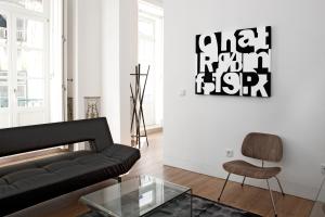 a living room with a black couch and a chair at LSA Baixa Chiado by Numa in Lisbon