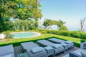 a garden with a swimming pool and lounge chairs at Le Relais du Lierre - Conero Nature Retreat in Poggio