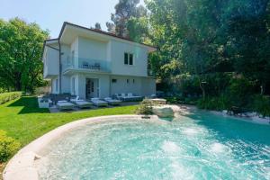 a house with a swimming pool in the yard at Le Relais du Lierre - Conero Nature Retreat in Poggio