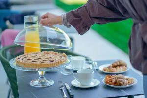 a person is serving a pie on a table at Le Relais du Lierre - Conero Nature Retreat in Poggio