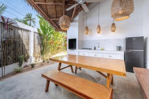 a kitchen with a wooden table and a bench at Blauset Two in General Luna