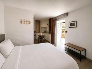 a bedroom with a large white bed and a kitchen at Storytellers Boutique Villas in Sintra