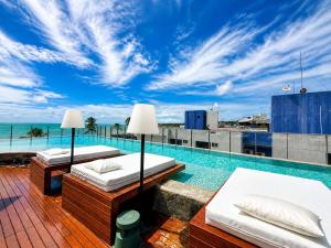 two beds on the roof of a building with a swimming pool at Setai Yatch Garden-Deluxe Praia-Piscina no rooftop in João Pessoa