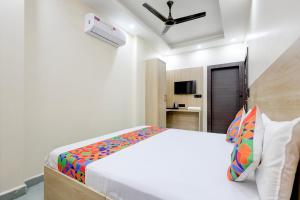 a bedroom with a bed and a ceiling fan at FabHotel Shivangan in Vrindāvan