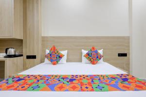 a bedroom with a large bed with a colorful comforter at FabHotel Shivangan in Vrindāvan