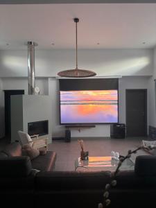 a living room with a large flat screen tv at Villa , Piscine Privée, Jacuzzi in Barbaggio
