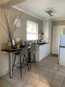 a kitchen with a table and chairs and a refrigerator at The Cottage on Alphen in Heathfield