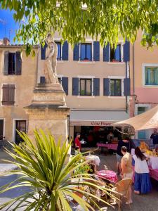 a statue of a woman standing in front of a building at La Clef de la Place in Leucate