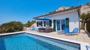 a villa with a swimming pool in front of a house at House Vissum by Villas Guide in Lukovo