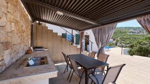 a patio with a table and chairs and a sink at House Vissum by Villas Guide in Lukovo