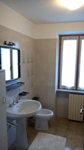 a bathroom with a sink and a toilet and a tv at Appartamenti Fabila in Castello Tesino