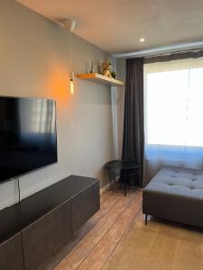 a living room with a flat screen tv and a couch at Dzivoklis ar saunu in Rēzekne