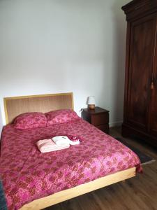 a bedroom with a bed with a purple comforter at La Flibuste in Andernos-les-Bains