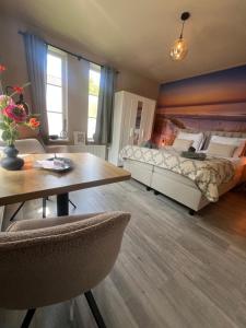 a bedroom with a bed and a table and chairs at Etoile aan Zee in Vrouwenpolder