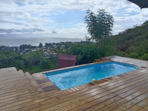 a swimming pool on a deck with a view of the ocean at Les Vavangues in Saint-Leu