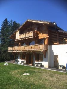 a large wooden building with a deck on it at Le cocon alpin in Passy