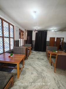 a living room with couches and tables and windows at Mountain Orchid in Manāli