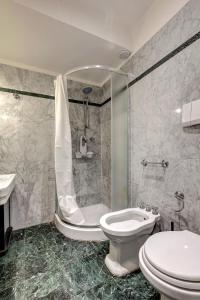 a bathroom with a toilet and a shower and a sink at Taddeo Apartement by Mamo Florence in Florence +14 photos