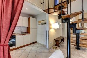 a kitchen with a spiral staircase with a red curtain at Taddeo Apartement by Mamo Florence in Florence