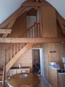 a loft with a wooden table and a staircase at Gîte EAU'DER in Giffaumont-Champaubert