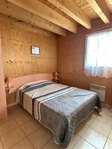 a bedroom with a bed in a wooden room at Gîte EAU'DER in Giffaumont-Champaubert