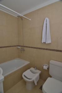 a bathroom with a white toilet and a bath tub at My Apart in Buenos Aires