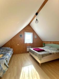 a attic bedroom with a bed and a window at Gîte EAU'DER in Giffaumont-Champaubert +11 photos