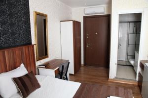 a hotel room with a bed and a desk and a bathroom at garden hill hotel in Istanbul
