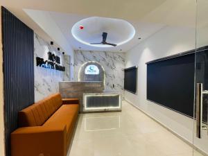 a waiting room with a couch and a large screen at Hotel Pacific Regency in Ahmedabad