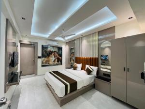 a bedroom with a large bed and a tv at Hotel Pacific Regency in Ahmedabad