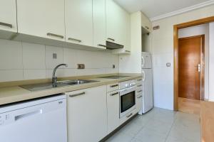 a kitchen with white cabinets and a sink at Gala Centro Modern I in Torrevieja