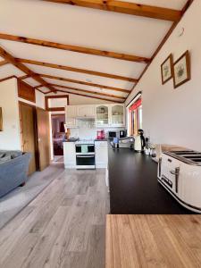 a large kitchen with white appliances and wooden ceilings at Hawthorn Self Catering Cottages in Benderloch