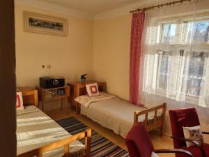 a small room with two beds and a television at Domek U hřiště in Hlinsko