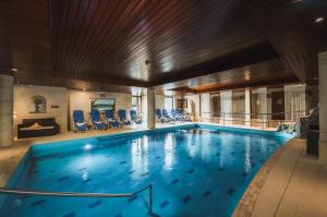 a large swimming pool with blue chairs in a building at Landhotel Spessartruh in Frammersbach
