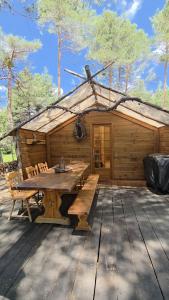 a wooden cabin with a wooden table and chairs at Destination Ailleurs eco-domaine & spa in Castellane +29 photos