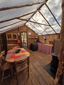 a room with a table and a kitchen in a tent at Destination Ailleurs eco-domaine & spa in Castellane