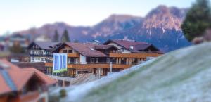 a group of buildings with a mountain in the background at Hotel Bergruh in Oberstdorf