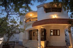 a large white house with a staircase in front of it at Kattil Madurai in Madurai