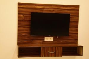 a flat screen tv sitting on top of a wooden wall at Hotel Bhatner Inn in Hanumāngarh