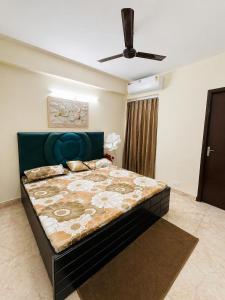 a bedroom with a large bed with a blue headboard at AM Living in Ghaziabad