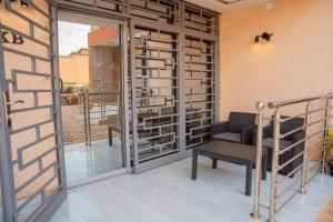 a room with a glass door and a chair on a balcony at Appartements Quartier Kabulameshi - Lubumbashi in Lubumbashi