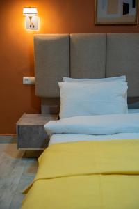 a bed with yellow sheets and pillows in a room at Appartements Quartier Kabulameshi - Lubumbashi in Lubumbashi