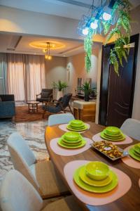a dining room with a table with green dishes on it at Appartements Quartier Kabulameshi - Lubumbashi in Lubumbashi