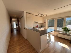 a kitchen with white cabinets and a black counter top at Ferienwohnung Heid in Rettenberg +10 photos